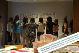 image of girls looking at papers on a wall . OPLA excellence in children's or teen services award