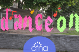 Dance On weaved into a fence with the CFNA logo