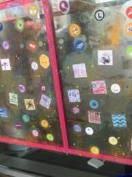 Plexiglass wall with little doodles pasted on it