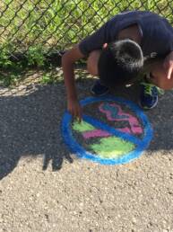 teen using chalk to make an anti smoking sign