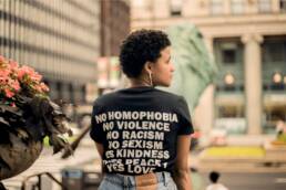 woman wearing tshirt that says No homophobia, no violence, no racism, no sexism, Yes to kindness peace and love